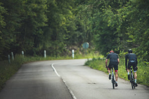 Deux cyclistes sur route en forêt