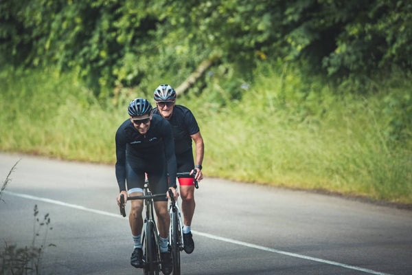 deux cyclistes sur route en forêt