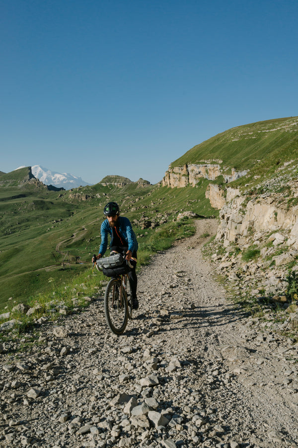 homme en gravel sur piste cailloux